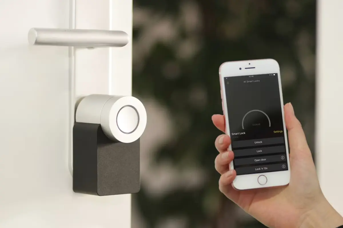 A smartphone held near a smart lock at a front door