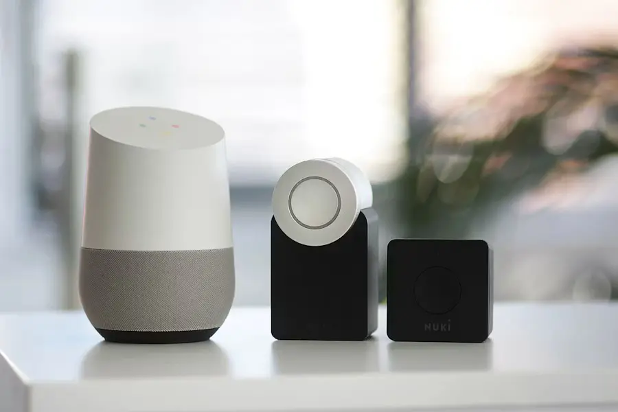 A white and grey smart speaker beside two black speakers